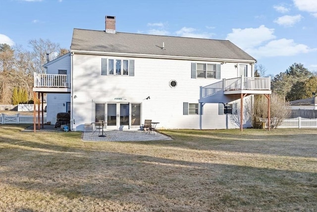 back of property with a yard and a patio