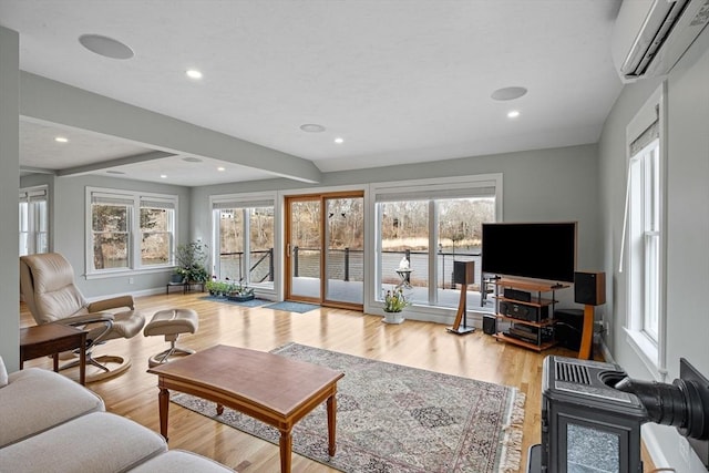 living room featuring a wall mounted air conditioner, baseboards, light wood-style flooring, and recessed lighting