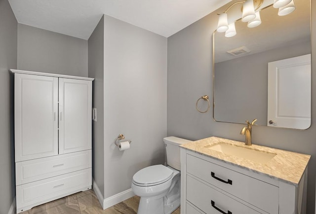 bathroom featuring visible vents, toilet, vanity, and baseboards