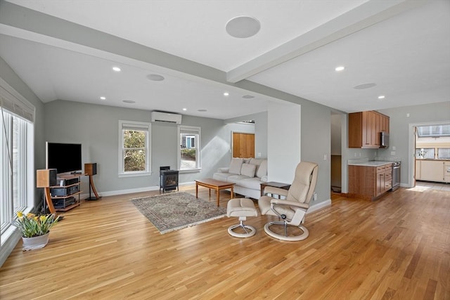 living room featuring a wall unit AC, baseboards, a wood stove, light wood-style flooring, and beamed ceiling