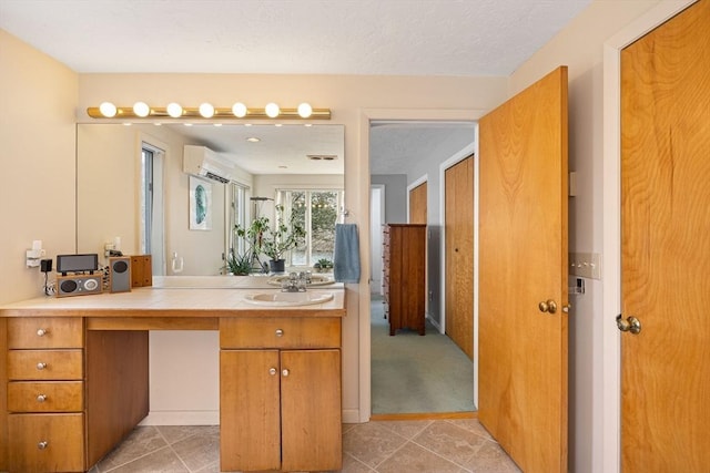 bathroom with vanity, tile patterned floors, a wall mounted air conditioner, and a textured ceiling