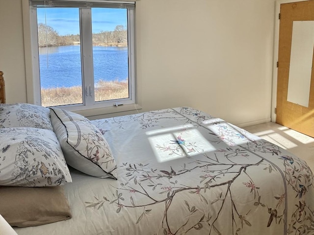 bedroom with multiple windows and a water view