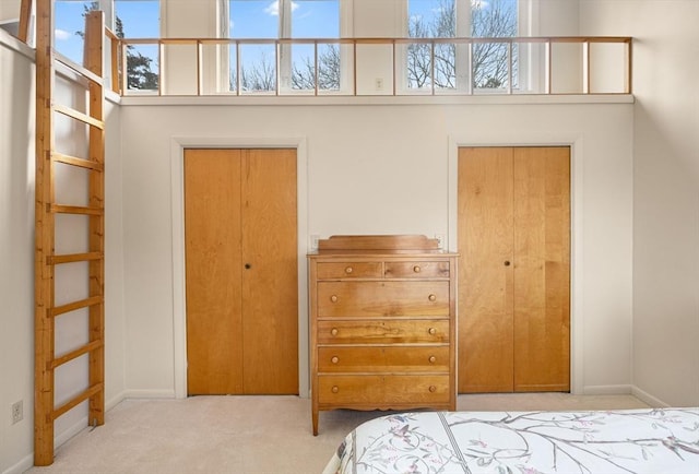 bedroom with carpet flooring, baseboards, and a towering ceiling