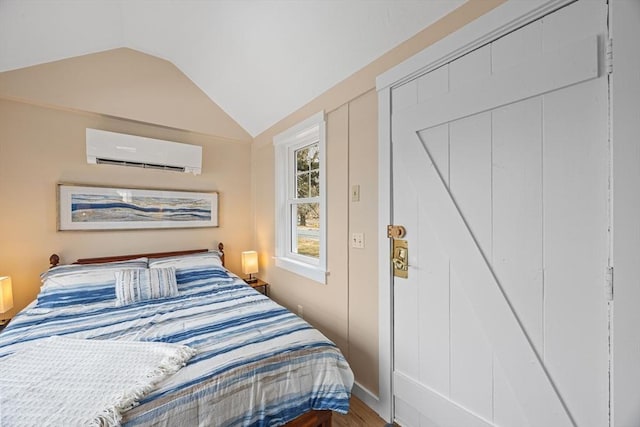 bedroom with a wall unit AC, a closet, and lofted ceiling