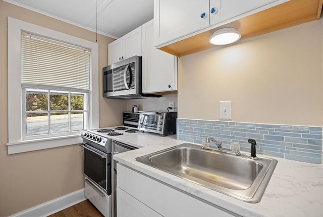 kitchen with a toaster, a sink, range with electric stovetop, white cabinetry, and stainless steel microwave