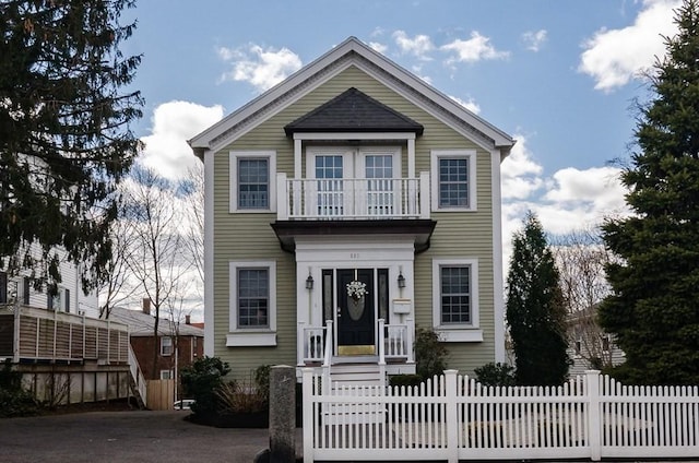 view of front of property with a balcony and a fenced front yard