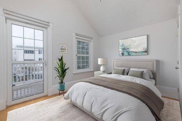 bedroom featuring vaulted ceiling, access to exterior, baseboards, and wood finished floors