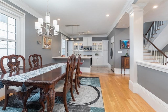 dining room with light wood-type flooring, recessed lighting, a notable chandelier, stairs, and ornamental molding