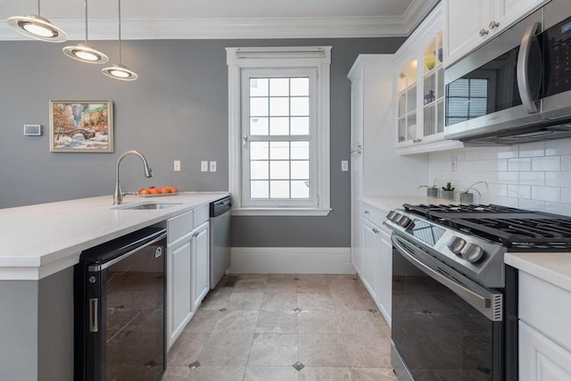 kitchen with stainless steel appliances, wine cooler, a sink, crown molding, and a peninsula