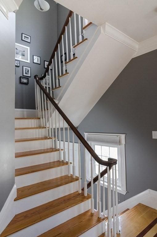 stairs featuring baseboards and a high ceiling