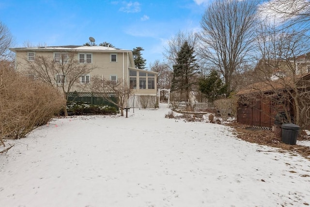 yard covered in snow with a sunroom