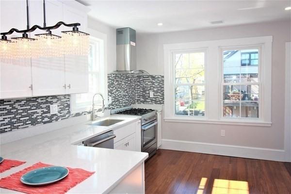 318 Concord Ave Unit 2, Cambridge, MA 02138 - kitchen featuring wall chimney exhaust hood, appliances with stainless steel finishes, a sink, light countertops, and recessed lighting