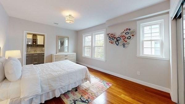 318 Concord Ave Unit 2, Cambridge, MA 02138 - bedroom featuring baseboards, wood finished floors, and connected bathroom
