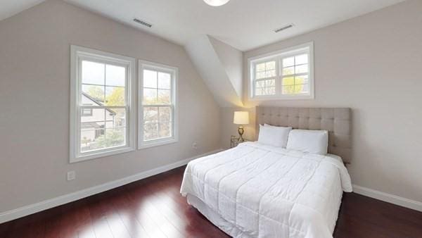 318 Concord Ave Unit 2, Cambridge, MA 02138 - bedroom featuring vaulted ceiling, multiple windows, wood finished floors, and baseboards