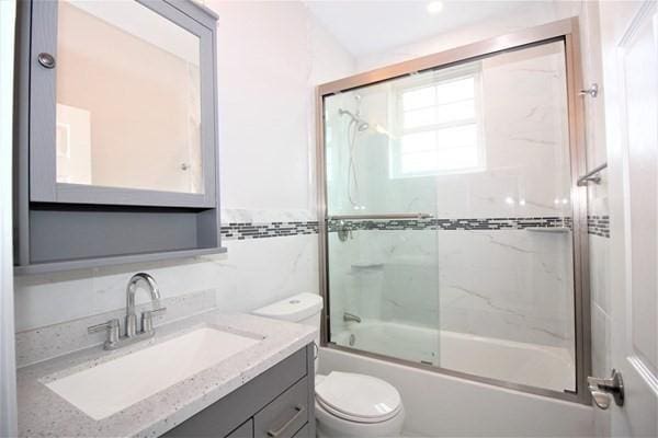 318 Concord Ave Unit 2, Cambridge, MA 02138 - full bathroom featuring toilet, bath / shower combo with glass door, vanity, and tile walls