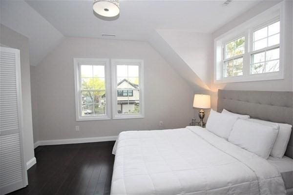 318 Concord Ave Unit 2, Cambridge, MA 02138 - bedroom with vaulted ceiling, multiple windows, wood-type flooring, and baseboards
