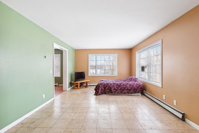 bedroom featuring a baseboard heating unit, baseboards, and a baseboard radiator