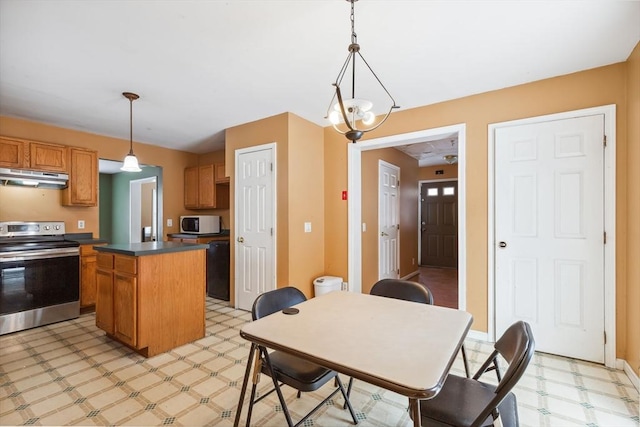 kitchen with white microwave, a center island, under cabinet range hood, light floors, and stainless steel range with electric stovetop