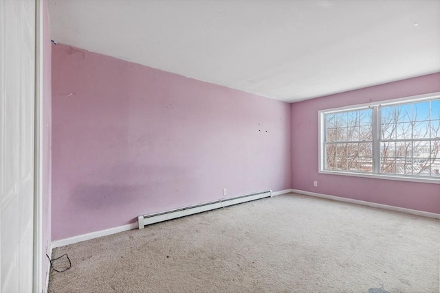 carpeted empty room featuring a baseboard heating unit and baseboards