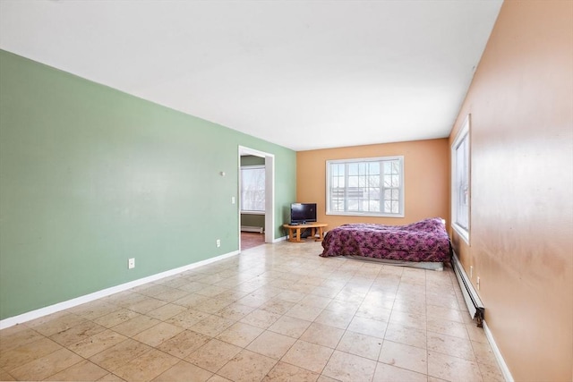 bedroom with a baseboard heating unit and baseboards