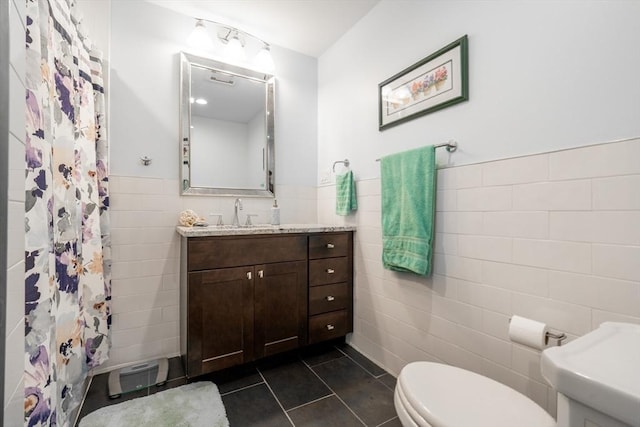 bathroom featuring tile walls, a shower with curtain, toilet, vanity, and tile patterned flooring