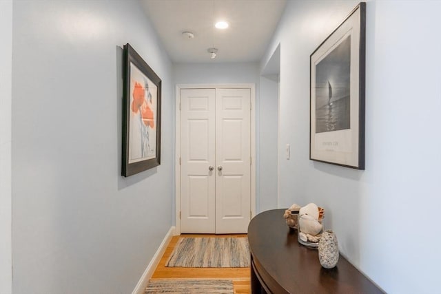 corridor with light wood-style floors, recessed lighting, and baseboards