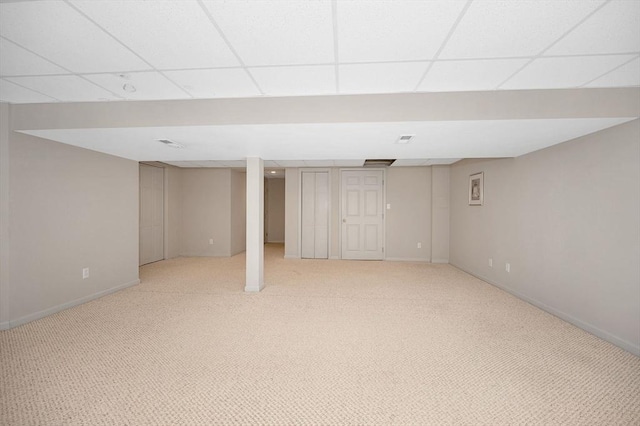 basement featuring a paneled ceiling and carpet flooring