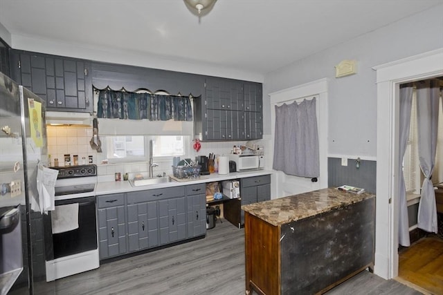 2278-2280 Main St, Palmer, MA 01080 - kitchen with white appliances, gray cabinetry, under cabinet range hood, light wood finished floors, and decorative backsplash