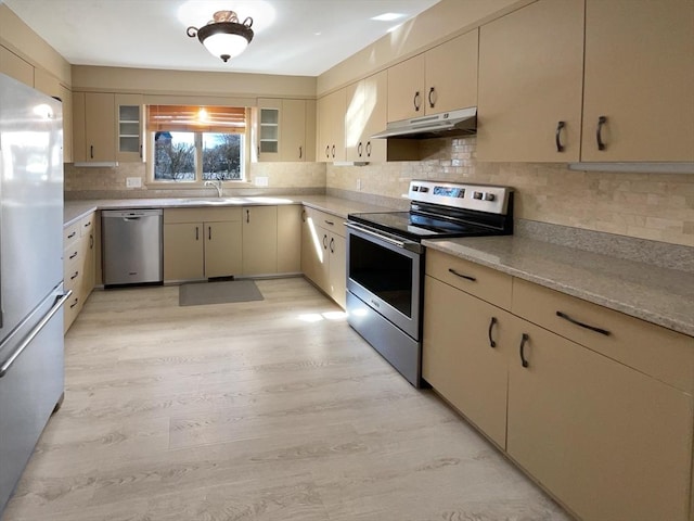 kitchen featuring under cabinet range hood, backsplash, and appliances with stainless steel finishes