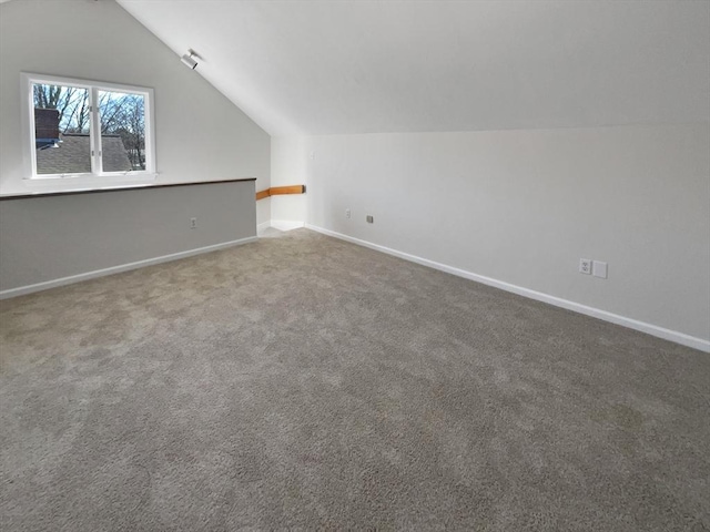 additional living space with carpet floors, baseboards, and vaulted ceiling