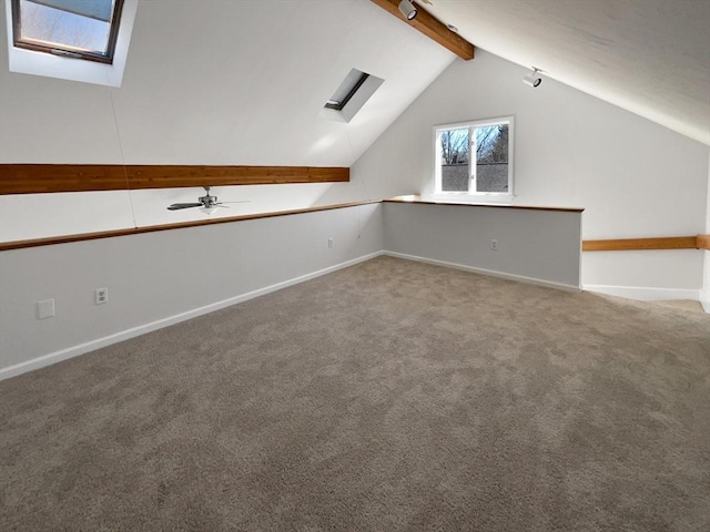 bonus room with baseboards, vaulted ceiling with skylight, and carpet