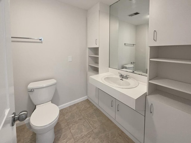 bathroom featuring visible vents, toilet, vanity, and baseboards