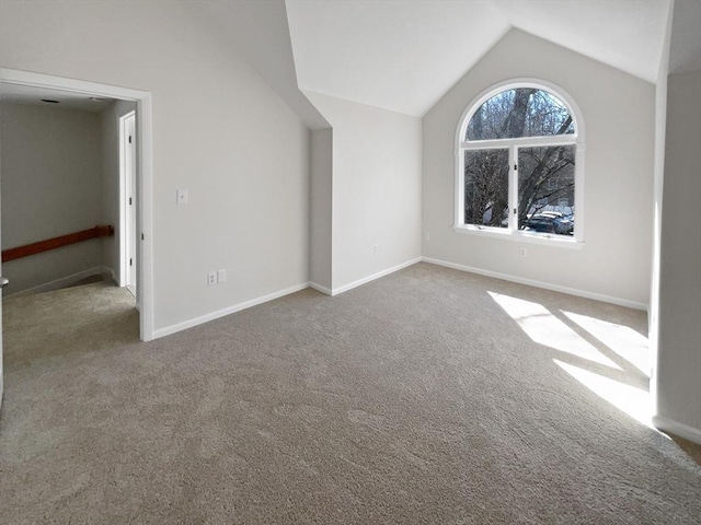 additional living space with baseboards, lofted ceiling, and carpet flooring