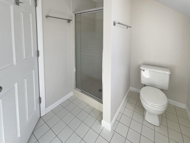 bathroom with tile patterned flooring, a shower stall, toilet, and baseboards