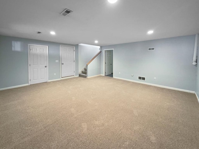 finished below grade area featuring stairway, baseboards, and visible vents