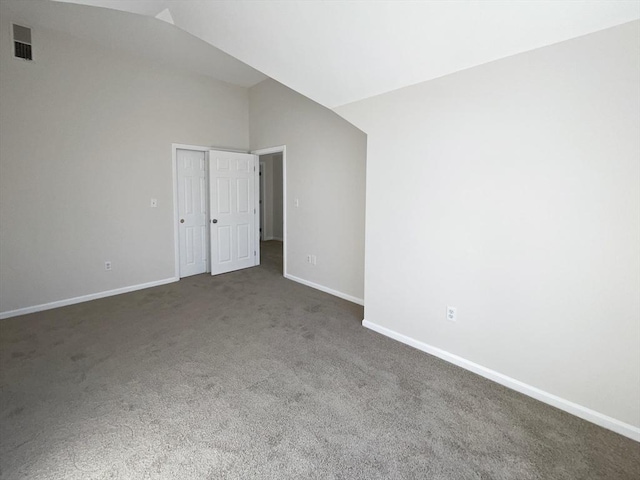 carpeted spare room featuring visible vents, lofted ceiling, and baseboards