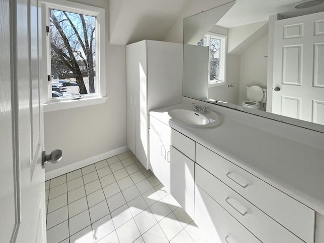 half bathroom featuring tile patterned floors, baseboards, toilet, and vanity