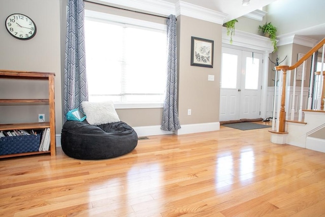 entryway featuring baseboards, stairway, crown molding, and wood finished floors