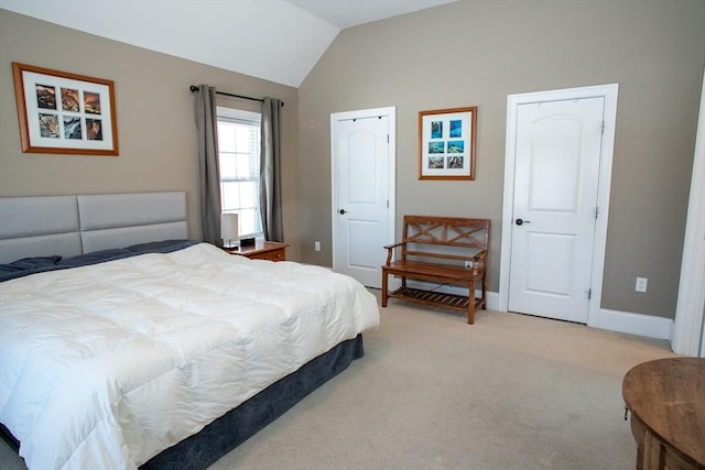 bedroom with lofted ceiling, light carpet, and baseboards