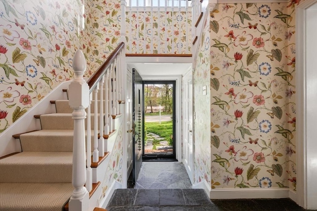 interior space featuring a healthy amount of sunlight, baseboards, and wallpapered walls
