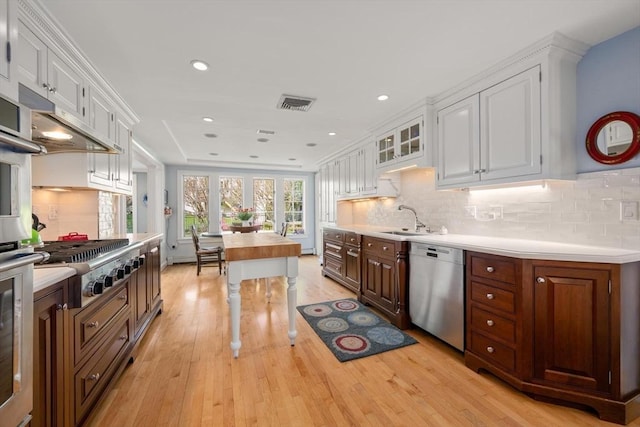 kitchen with visible vents, a sink, light countertops, white cabinets, and stainless steel appliances