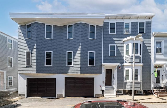 view of property with an attached garage, driveway, and entry steps