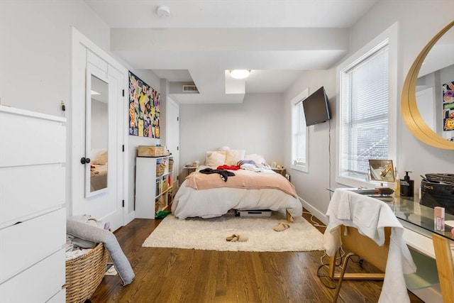 bedroom featuring wood finished floors and baseboards