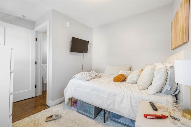 bedroom with wood finished floors and baseboards