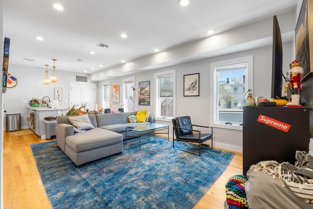 living area with recessed lighting, light wood-type flooring, a chandelier, and baseboards