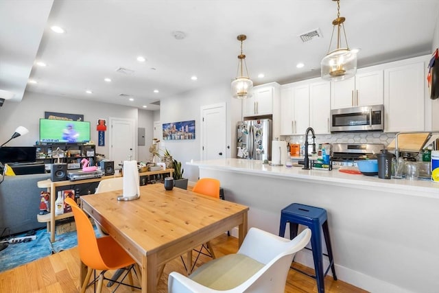 dining area with light wood-style floors and recessed lighting