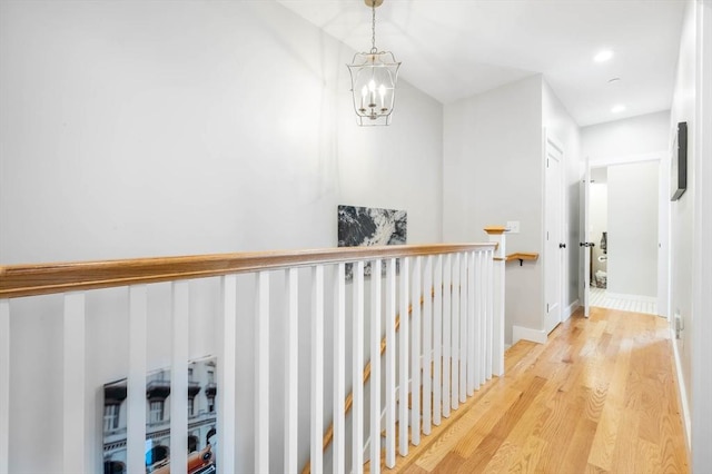 corridor with wood finished floors, a chandelier, an upstairs landing, recessed lighting, and baseboards