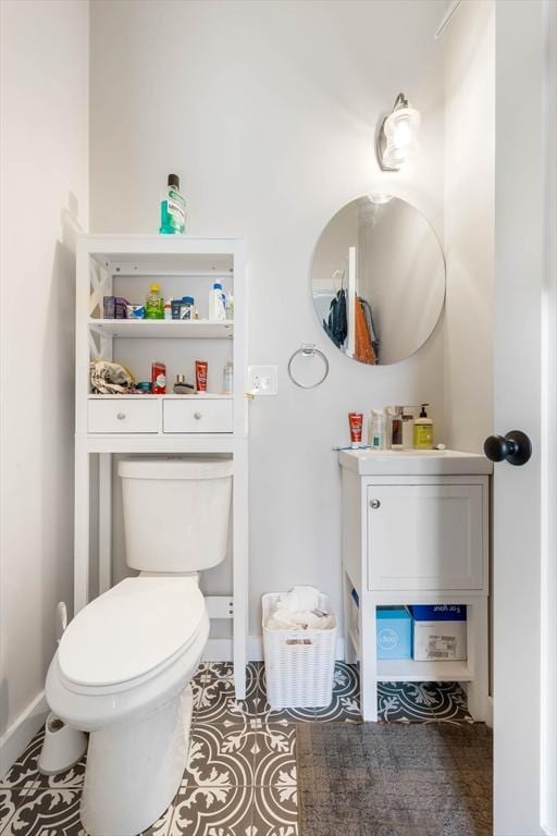bathroom featuring toilet, vanity, baseboards, and tile patterned flooring
