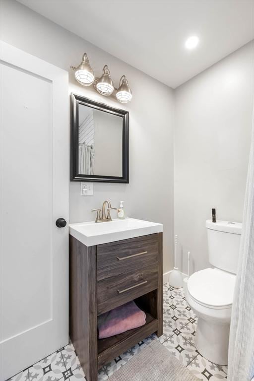 bathroom with toilet, vanity, and recessed lighting