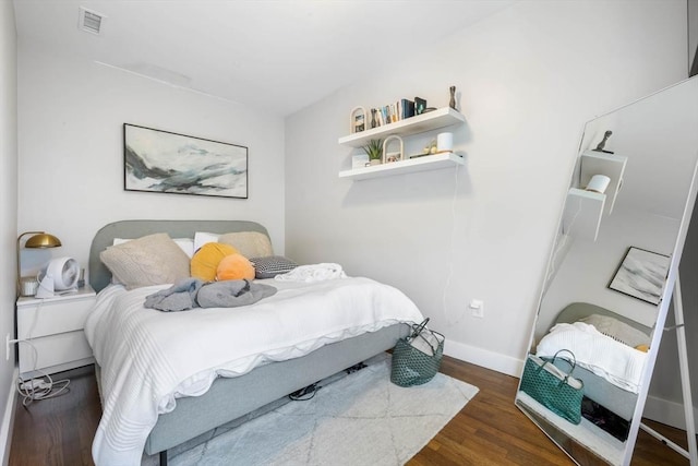 bedroom with wood finished floors and baseboards